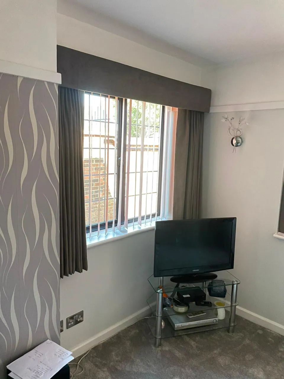 Grey curtains with a matching upholstered pelmet at a living room window